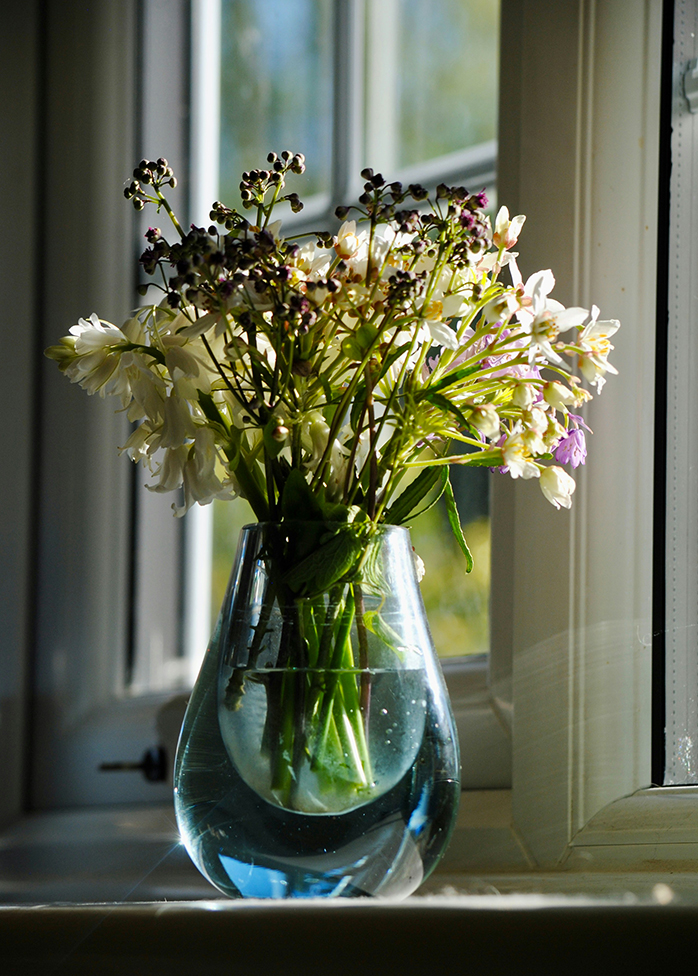 Bouquet printanier dans un vase en verre près d’une fenêtre