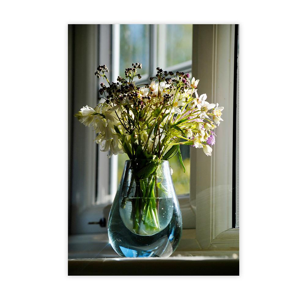 Bouquet printanier dans un vase en verre près d’une fenêtre