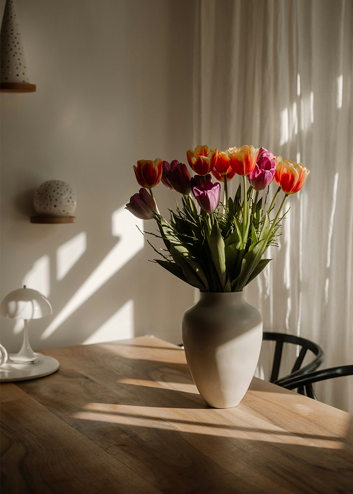 Bouquet de tulipes colorées dans un vase avec jeux d’ombres et de lumière